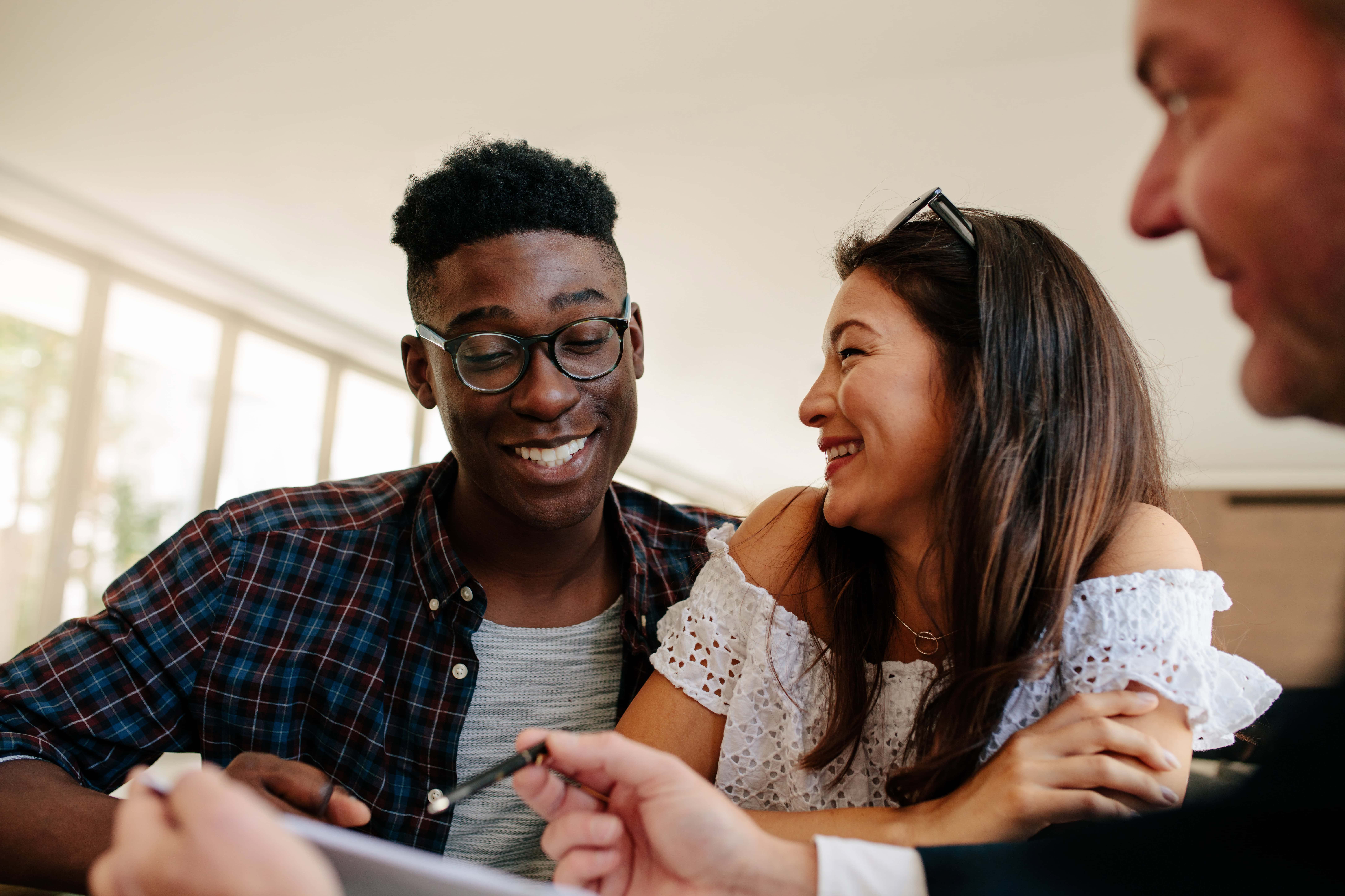 A happy couple sign final documents for their home loan