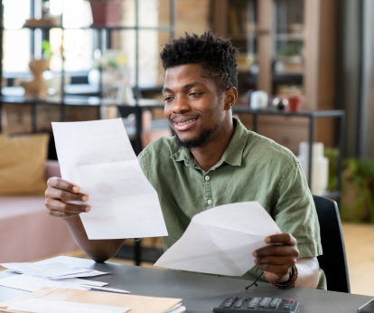 man smiling looking at financial document